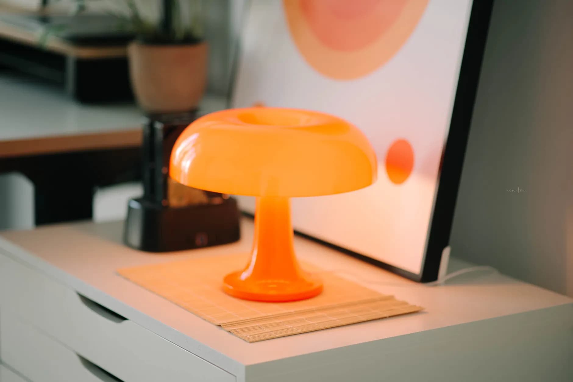 Orange decorative table lamp on a white cabinet